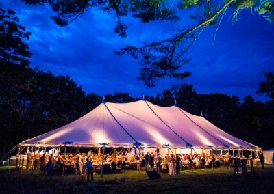 A large tent is illuminated at night during a gorgeous Churchill Events outdoor Maine wedding. Photo Courtesy of Andree Kehn http://andreekehn.com